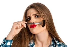 drôle de beauté femme joue avec un pinceau de maquillage photo