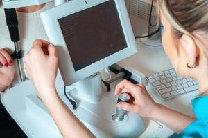 médecin vérifie les yeux d'un patient à l'aide de l'appareil ophtalmique photo