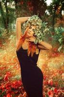 superbe jeune femme adulte mince avec des cheveux roux et une couronne de houblon sur la tête photo