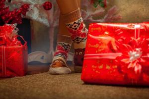 photo horizontale de jambes féminines dans des chaussettes amusantes avec beaucoup de cadeaux de noël