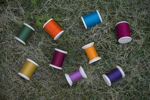 fils multicolores sur l'herbe verte pour le fond de couture photo