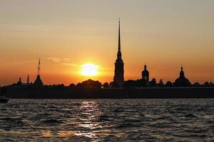 la silhouette de la forteresse pierre et paul au coucher du soleil, vue depuis la rivière neva photo