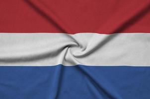le drapeau néerlandais est représenté sur un tissu de sport avec de nombreux plis. bannière de l'équipe sportive photo