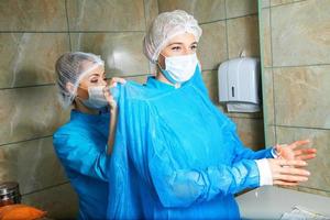 jeune femme médecin se préparant à l'opération avec un assistant photo