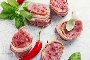 médaillons de filet de porc cru avec bacon enveloppé photo