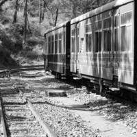 train jouet se déplaçant sur le versant de la montagne, belle vue, une montagne latérale, une vallée latérale se déplaçant sur le chemin de fer vers la colline, parmi la forêt naturelle verte. train jouet de kalka à shimla en inde-noir et blanc photo