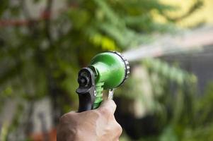 photo d'un jardinier utilisant un jet d'eau pour arroser les plantes.