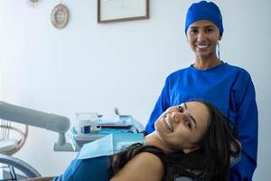 femme dentiste et son patient sourient en regardant la caméra. photo