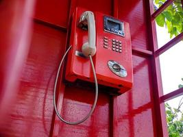 le vieux téléphone filaire rouge dans le passé, c'est comme retourner dans le passé où les gens utilisaient souvent les téléphones publics. photo