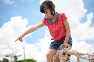 une petite fille s'amusant à se balancer sur une balançoire par temps clair photo