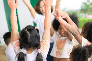 les enfants s'amusent à jouer avec les couleurs. ils se tiennent la main photo