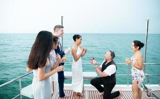 le moment approprié pour un homme blanc de proposer d'épouser une femme asiatique. sur un yacht flottant dans la belle eau. photo