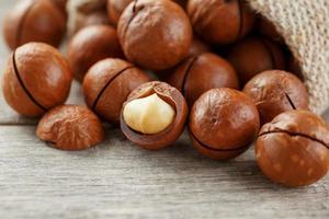 noix de macadamia sur une table en bois dans un sac, gros plan, vue de dessus photo