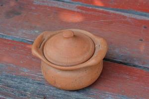 la vue de dessus du pot court en argile est sur la table en poterie située sur une table en bois. photo