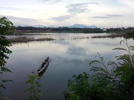 bateau traditionnel en bois flottant sur les eaux du lac limboto, gorontalo, indonésie. petite chaloupe en bois sur un lac calme photo