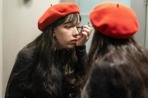 jeune fille élégante se maquillant avec un eye-liner photo