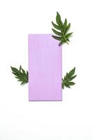 enveloppe vierge violette et feuilles de chardon sur fond blanc. maquette pour invitation ou carte de voeux. photo