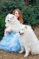 belle jeune fille rousse en longue robe verte avec trois samoyèdes en plein air photo