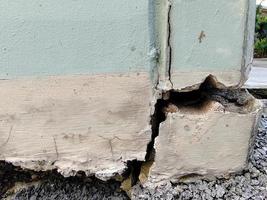 gros plan d'un bâtiment en béton fissuré ou d'un mur de ciment de pilier cassé à l'extérieur avec un tremblement de terre photo