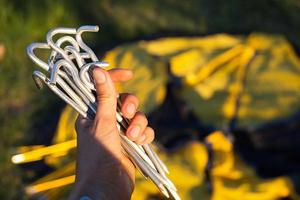 piquets en aluminium pour l'installation d'une tente touristique jaune en gros plan à la main. équipement léger pour le tourisme. activités de plein air, instructions de montage, écotourisme domestique. copie espace photo