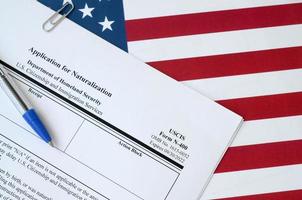 Le formulaire vierge de demande de naturalisation n-400 se trouve sur le drapeau des états-unis avec un stylo bleu du département de la sécurité intérieure photo