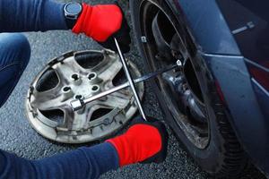 homme changeant de crevaison sur sa propre voiture photo