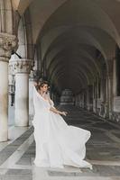 jeune femme portant une belle robe blanche dans une arche près de la piazza san marco photo