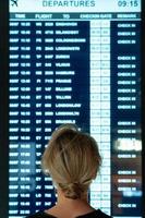 femme regardant sur l'écran avec des informations sur un vol dans un aéroport photo