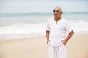 heureux homme âgé marchant sur la plage photo