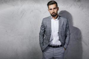 bel homme barbu vêtu d'un costume à carreaux gris photo