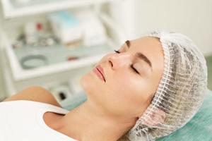 femme portant un chapeau stérile avant traitement dans une clinique médicale esthétique photo