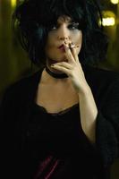femme bizarre aux cheveux noirs fumant une cigarette photo
