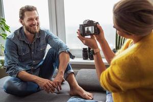 femme photographe prenant des photos de son petit ami à la maison