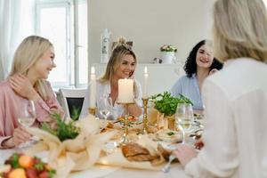 amis de jeunes femmes riant à la table de fête. photo