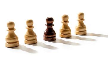 un pion d'échecs noir parmi les blancs. concept de racisme et de discrimination. photo