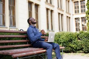 homme célébrant à l'extérieur avec un ordinateur portable photo