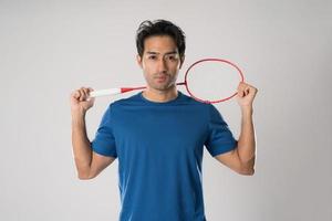 joueur de badminton portant des vêtements de sport debout tenant une raquette. photo