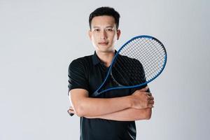 un joueur de tennis masculin tenant une raquette de tennis avec une expression et des yeux déterminés. photo