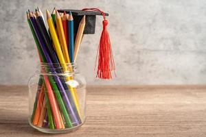 chapeau de graduation avec des crayons colorés sur un livre avec espace de copie, apprentissage du concept d'éducation universitaire. photo