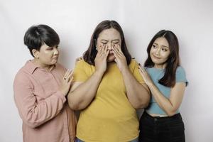 un portrait de trois amis à la recherche de pleurs tristes a essuyé ses larmes et s'est embrassé, fond blanc isolé photo