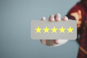 main montrant une excellente note cinq étoiles. les meilleurs excellents services aux entreprises évaluant l'expérience client, l'évaluation, la satisfaction, les commentaires, le concept d'examen. photo