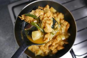 faire cuire du poulet au curry dans une poêle photo