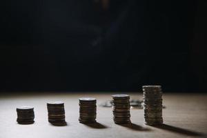 homme d'affaires détenant des pièces de monnaie mettant en verre. concept d'économiser de l'argent pour la comptabilité financière photo