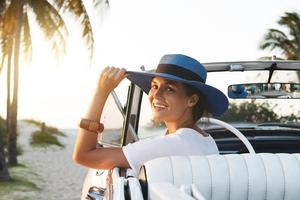 heureuse jeune femme et voiture décapotable rétro photo