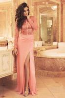 magnifique femme vêtue d'une belle robe dans la salle de bains de luxe photo
