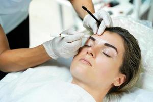 femme pendant la procédure de cartographie professionnelle des sourcils photo