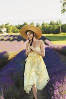 belle jeune femme dans un champ plein de fleurs de lavande photo