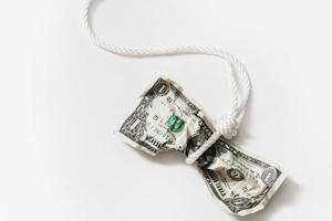 corde blanche emmêlée autour d'un billet d'un dollar froissé. photo