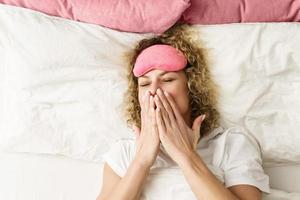 belle femme aux cheveux bouclés se réveillant après un bon sommeil photo