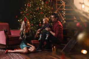 une jeune famille heureuse célèbre noël ou le nouvel an. photo